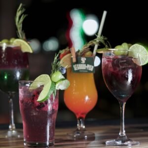 Colorful cocktails with fresh garnishes on a wooden surface, perfect for social gatherings.